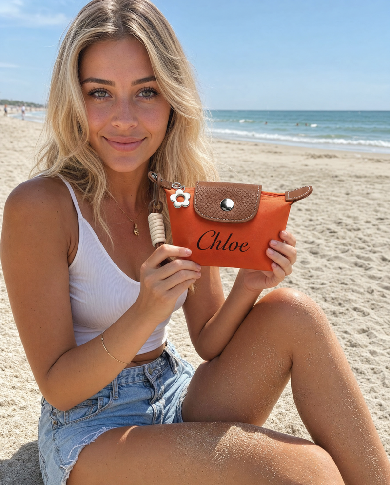 Woman holding a personalized brown mini pouch with custom name Chloe at the beach