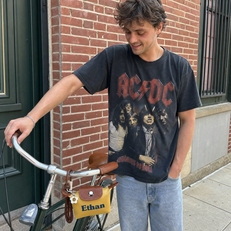 Man riding a bicycle with a personalized small bag featuring custom name Ethan