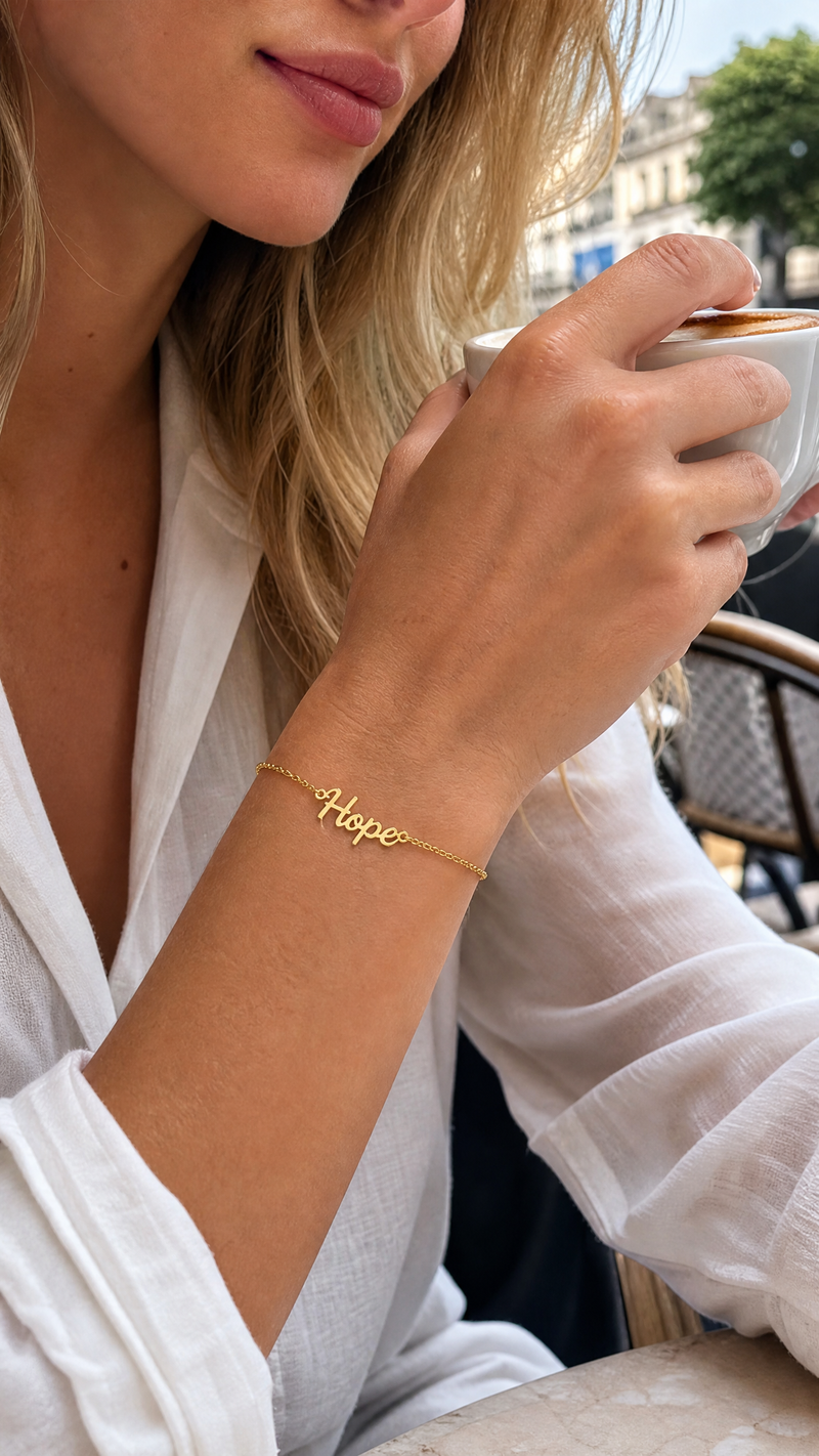 Close-up of a woman wearing a personalized gold name bracelet with custom name Harper