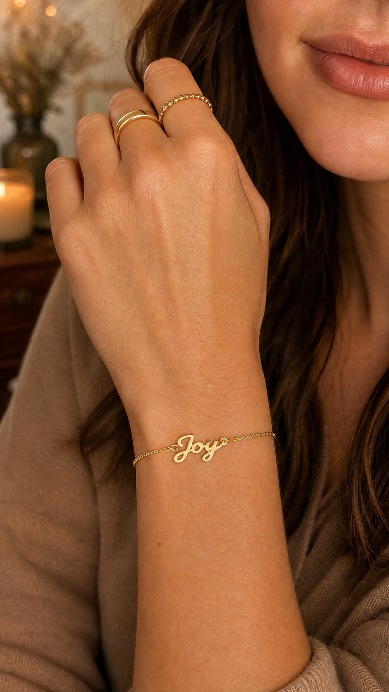 Close-up of a woman wearing a personalized name bracelet with Joy inscription