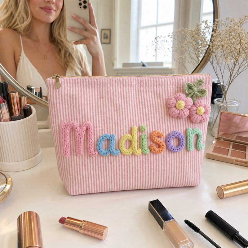 Personalized pink striped makeup bag with custom name styled with makeup essentials